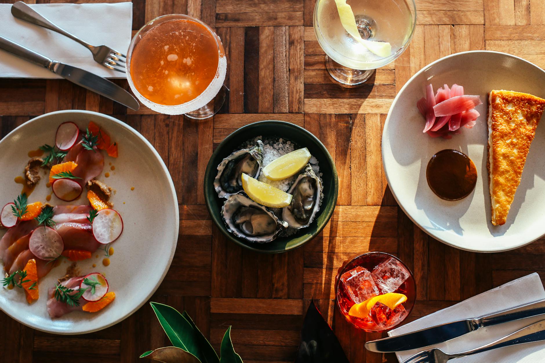 assorted seafood served on table with cocktails glasses and piece of tasty cake