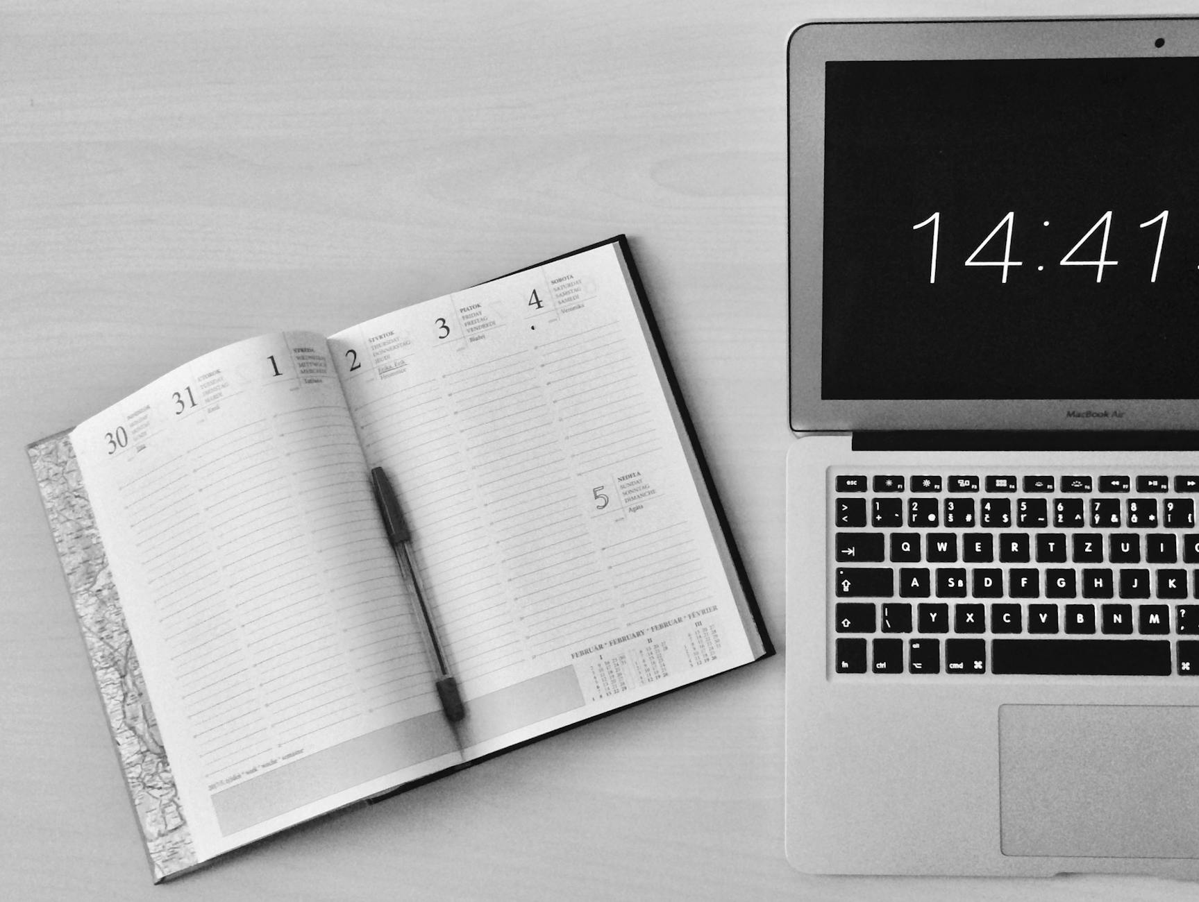 flat lay photography of unfold book beside macbook