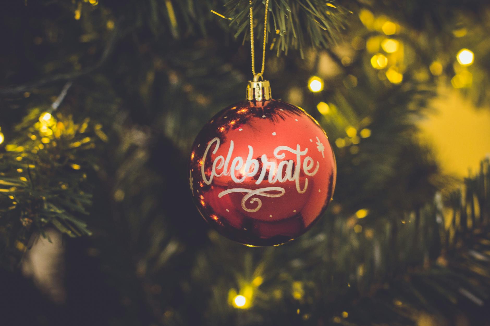 red celebrate print baubles hang on green christmas tree